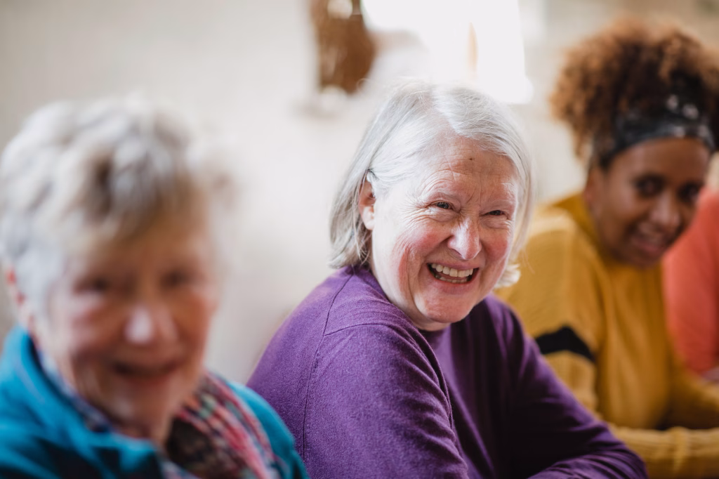 Smiling elderly women spending time together in a warm communal setting at Oakham Grange residential care home